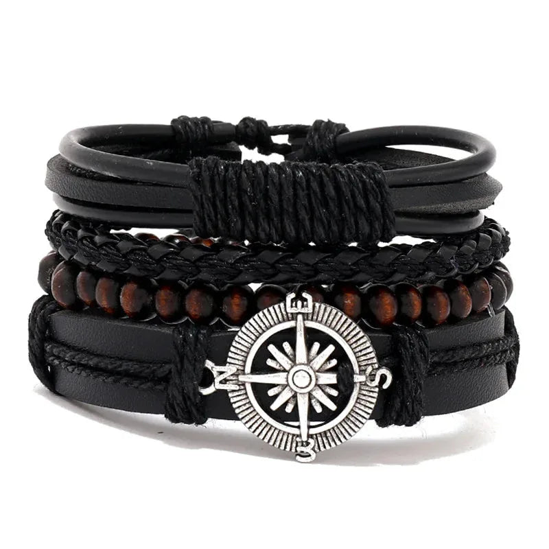 Black leather layered bracelet stack with a silver compass charm and brown wood beads, on a white background.