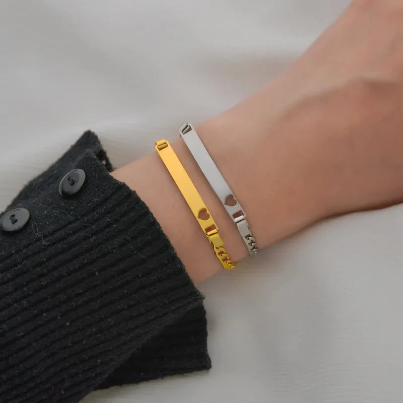 Wrist wearing stacked gold and silver Bond chain bracelets