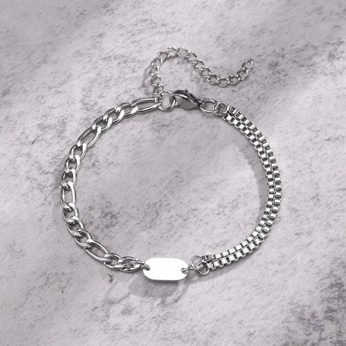 Insignia double-layer figaro and box chain bracelet with blank ID tag on a marble surface
