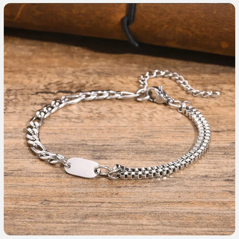 Insignia stainless steel chain bracelet coiled on a wooden surface
