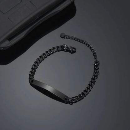 Blank black nameplate bracelet resting beside a phone case