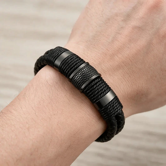 Multi-strand black woven leather bracelet with a dark metal magnetic clasp, worn on a man's wrist.