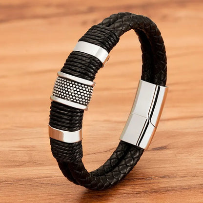 Silver woven leather rope bracelet with textured stainless steel rondelle beads, on a wood background