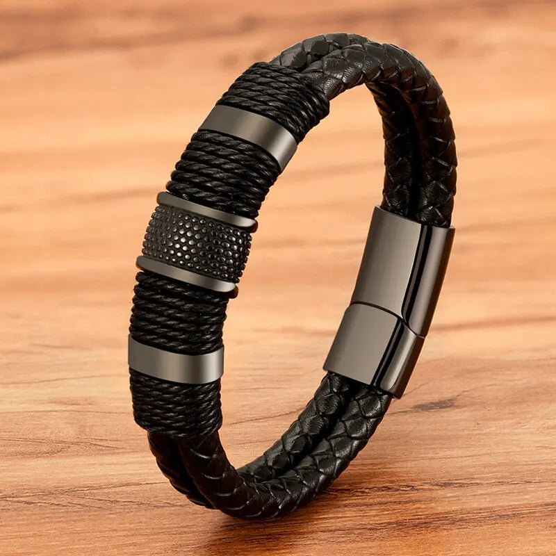 Black woven leather rope bracelet with textured stainless steel rondelle beads, on a wood background