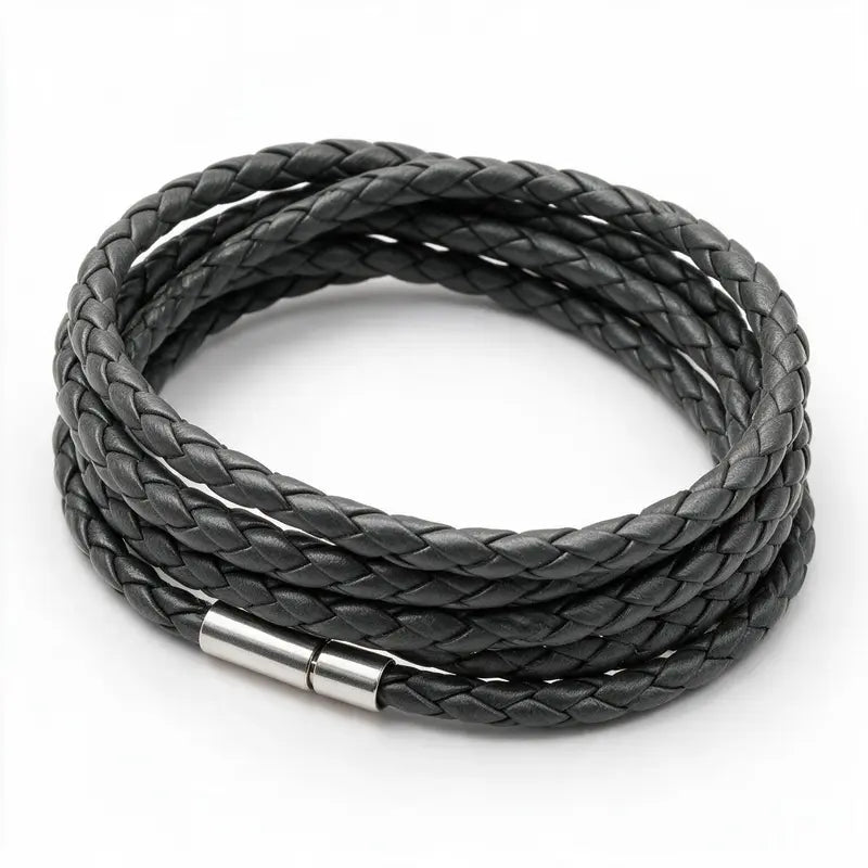 Charcoal grey braided leather bracelet coiled in a loop, on a white background.
