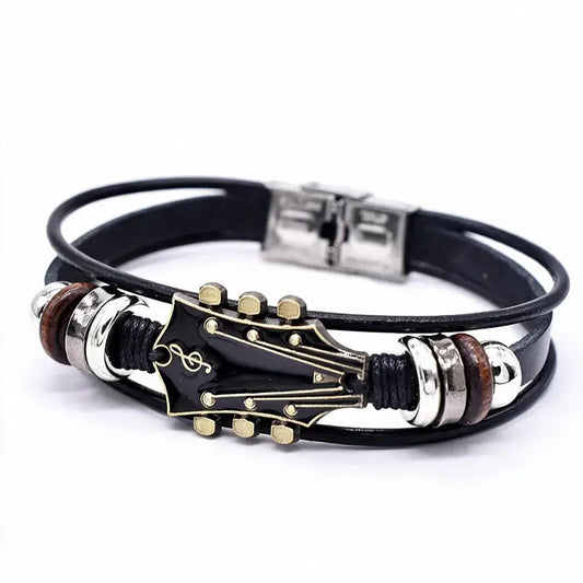 Black leather bracelet with a black enamel guitar headstock charm, on a white background.