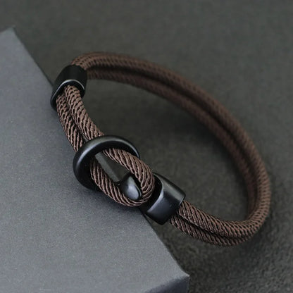Close-up of the black alloy hook clasp on a brown double-wrap rope bracelet