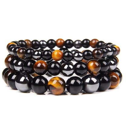 Triad Protection bracelets layered on a tray, tiger eye and black obsidian beads