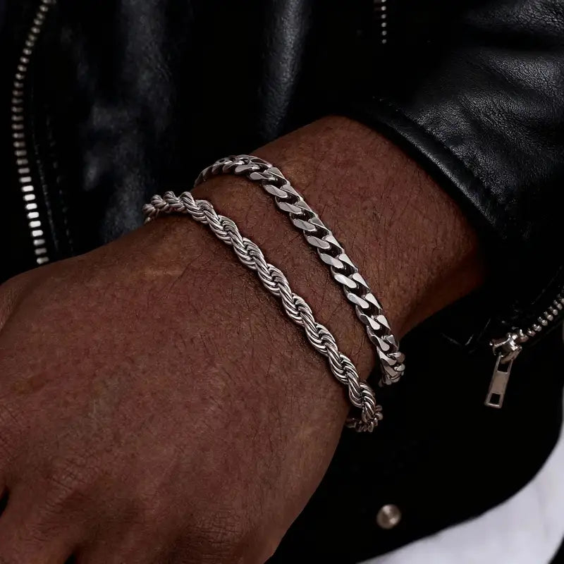 Silver twisted rope chain and Cuban curb chain bracelets worn together on the wrist