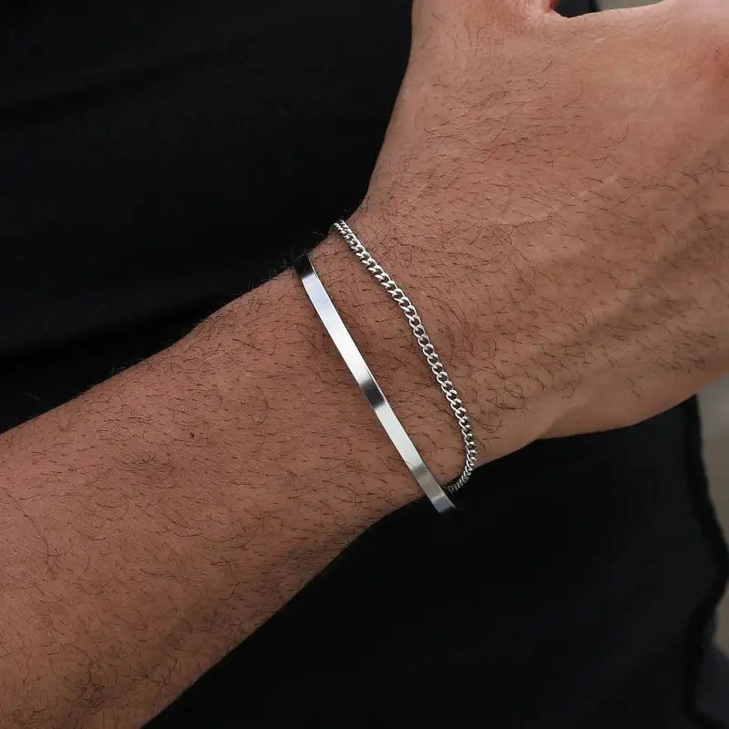 Silver chain and flat bar bracelet worn on the wrist, close-up