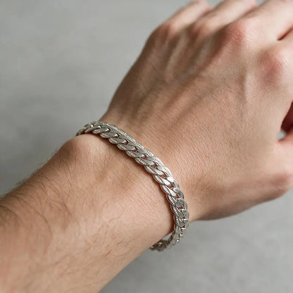 Silver flat curb chain bracelet worn on a man's wrist