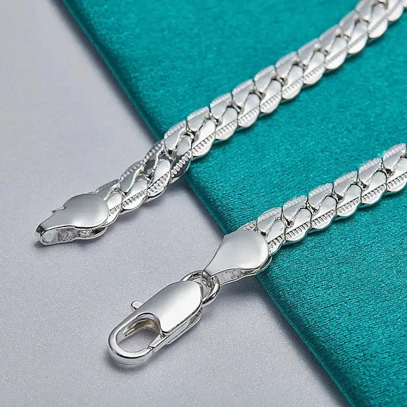 Close-up of the lobster clasp on a silver flat curb chain bracelet