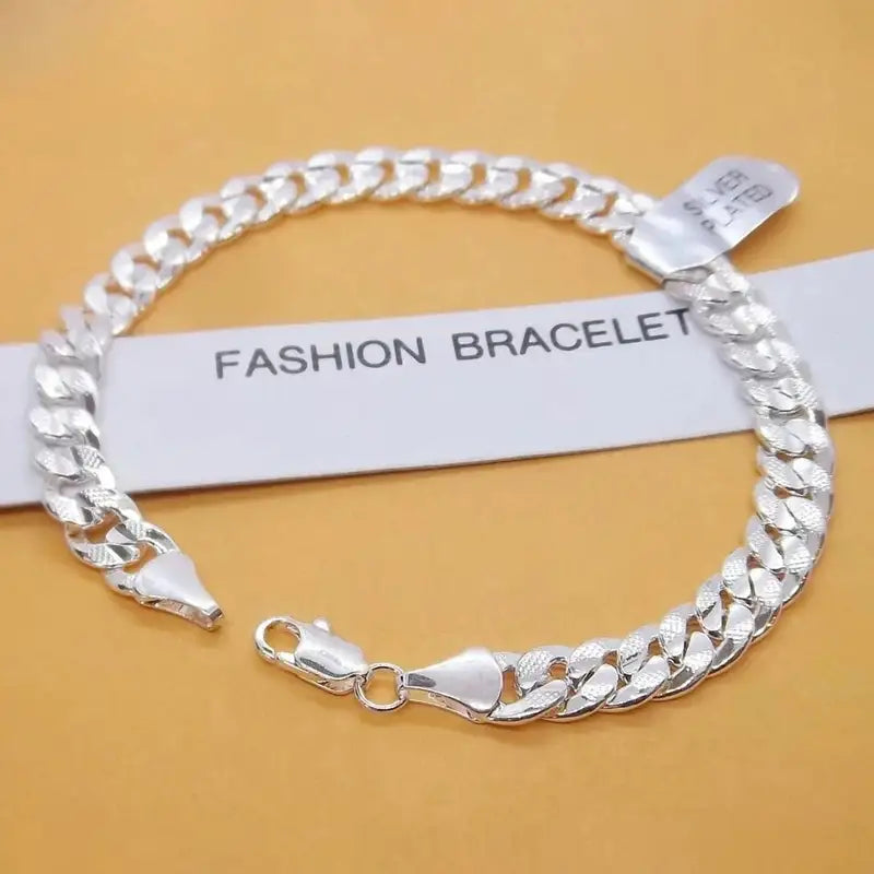 Silver flat curb chain bracelet with a diamond-cut texture and lobster clasp, labeled fashion bracelet