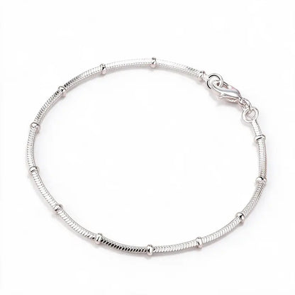 925 sterling silver thin snake chain bracelet with polished bead stations, product photo on white background
