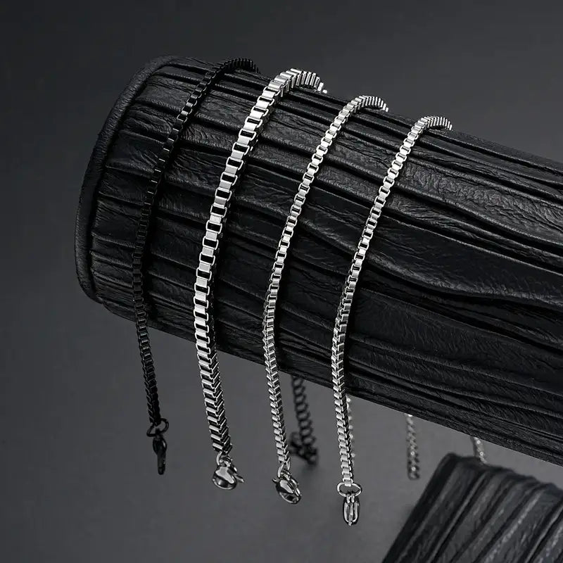 Silver and black box chain bracelets of different widths displayed together