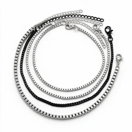 Set of four stainless steel box chain bracelets, three silver and one black, each with a lobster clasp and extension chain, product photo on white background