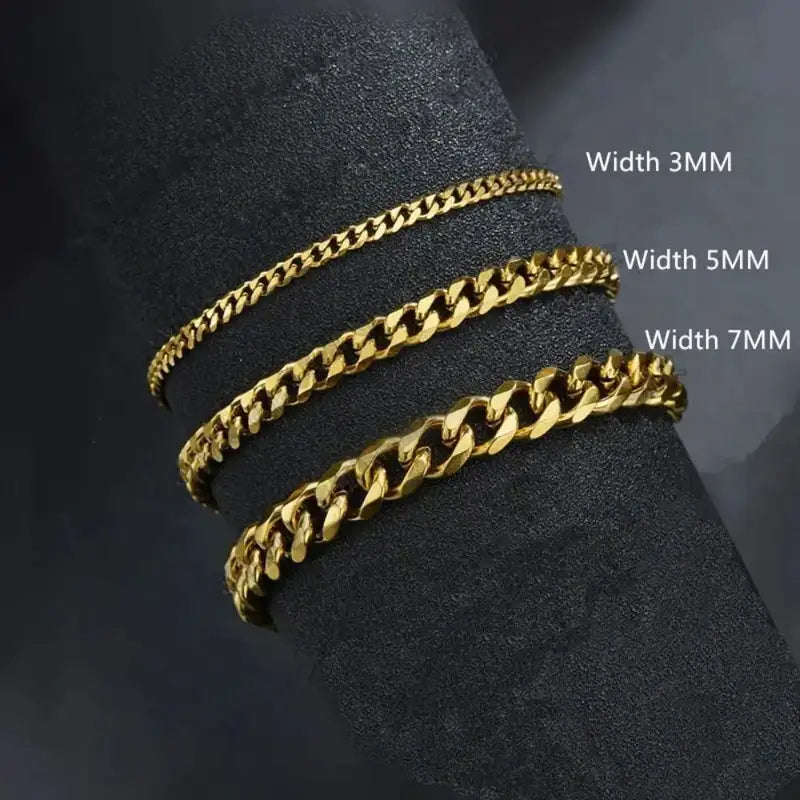 Gold Cuban link chains in 3mm, 5mm and 7mm widths compared on a dark display stand