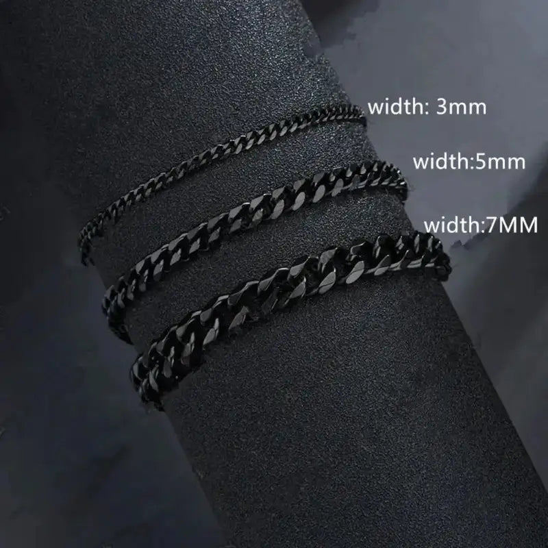 Black Cuban link chains in 3mm, 5mm and 7mm widths compared on a dark display stand