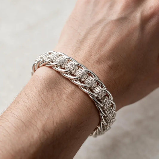 Thick silver braided rope-link chain bracelet worn on the wrist