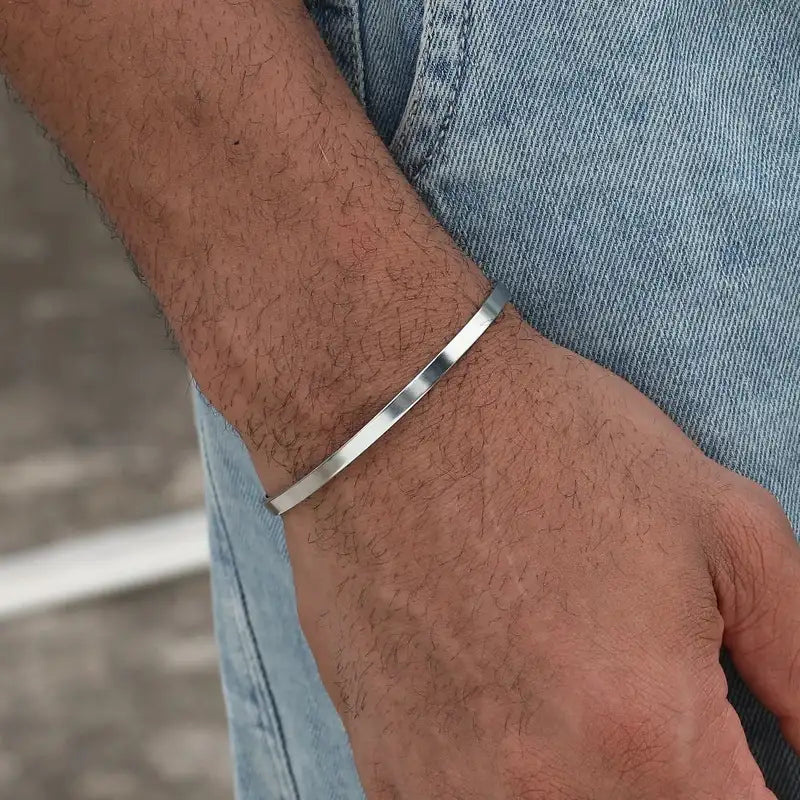 Silver open cuff bracelet worn on the wrist