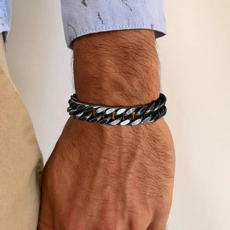 Man in a white t-shirt and cap wearing a black stainless steel Cuban link bracelet on his wrist