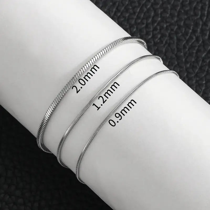 Silver snake chain bracelets in 2.0mm, 1.2mm and 0.9mm widths compared on the wrist