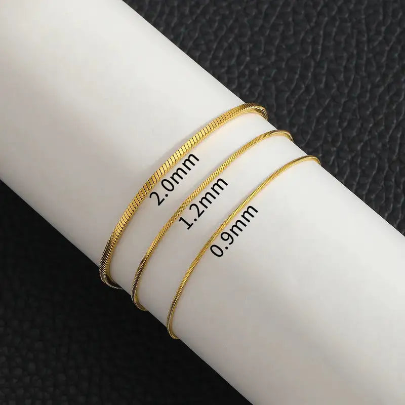 Gold snake chain bracelets in 2.0mm, 1.2mm and 0.9mm widths compared on the wrist
