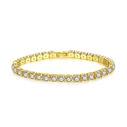 Gold tennis bracelet with round cubic zirconia stones laid flat in an oval on a plain white background.