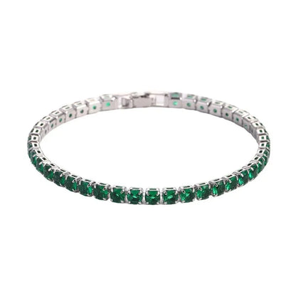 Tennis bracelet with green emerald-coloured stones in a silver setting, on a plain white background