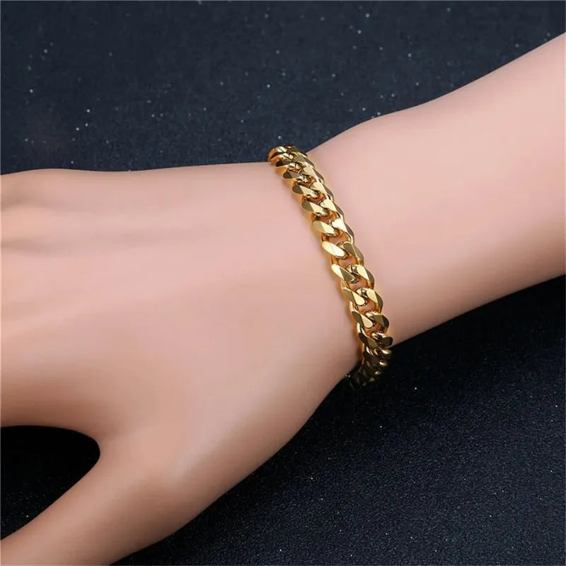 Silver-tone curb-link chain bracelet worn on a hand against a dark, glittery background.