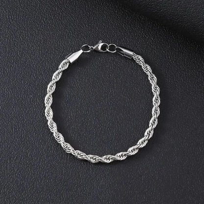 Silver-tone twisted rope chain bracelet laid flat in a circle on a black textured surface.