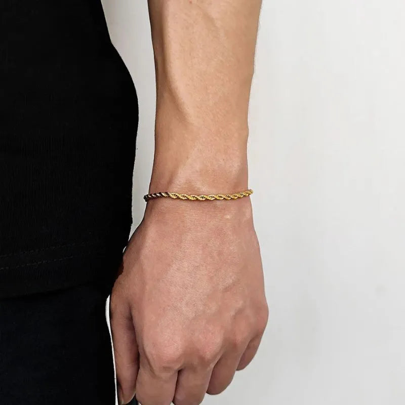 Gold twisted rope chain bracelet worn on the wrist, side profile against a white background.
