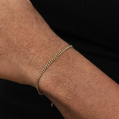 Gold Cuban link bracelet worn on the wrist, shown close-up against a plain black background.