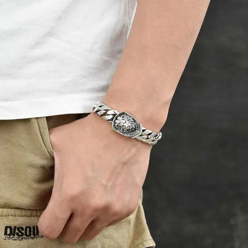 Close-up of the Men's Bracelet Silver featuring an engraved lion clasp and polished Cuban chain in sterling silver.