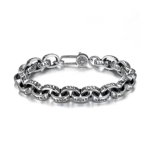 Silver oval-link chain bracelet with engraved Tibetan mantra script, laid in an oval on a plain white background, showing the round decorative clasp.