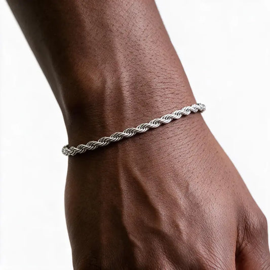 Silver stainless steel twisted rope chain bracelet worn on wrist, white background