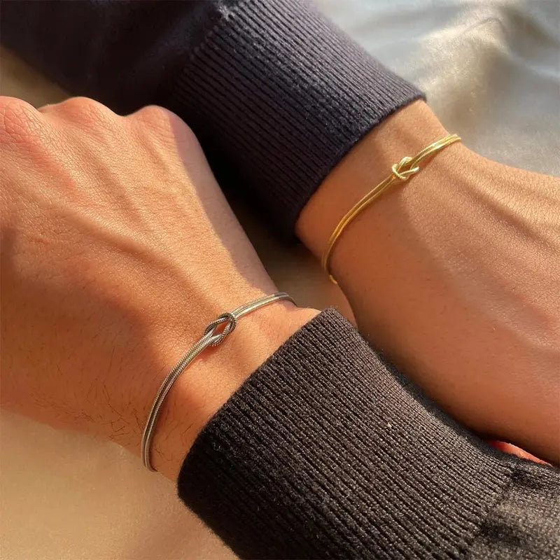 Gold and silver stainless steel knot chain bracelets worn as a couple set