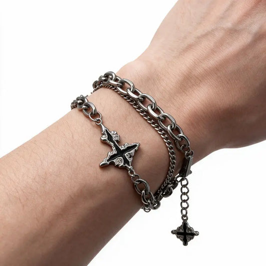 Dark stainless steel cross bracelet worn on wrist, white background